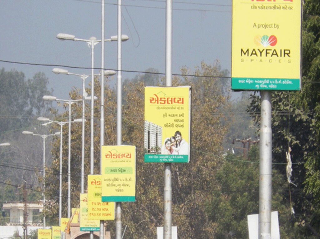 Pole kiosk advertising in Mumbai by ACME Advertising Co., showcasing vibrant street-level branding on high-traffic roads.