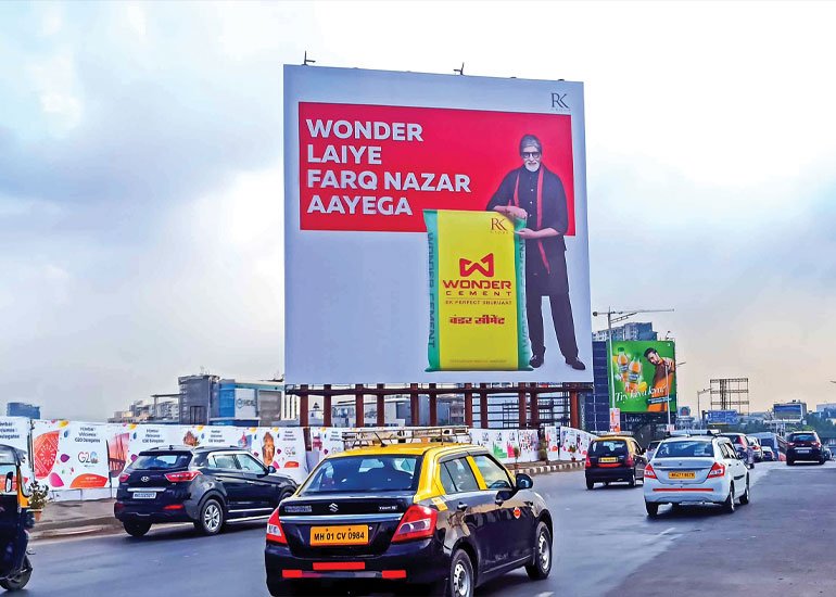 Highway outdoor advertising campaign featuring Wonder Cement billboard targeting commuters on a busy urban road.