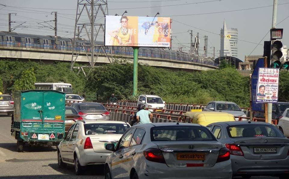 High-Visibility Outdoor Unipole Advertising by Acme Advertiser in East Delhi Large outdoor Unipole by Acme Advertiser displayed on a busy roadside, showcasing high-impact hoarding advertising for brand visibility in urban India.Β Digital Billboard Advertising Companies in DelhiΒ