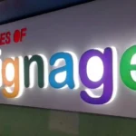"Colorful 3D backlit signage board with text 'All Types of Signage' on a wall"