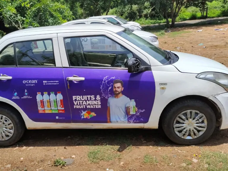 "Ocean Beverages cab branding on Swift Dzire – taxi wrap campaign by ACME Advertising in Delhi NCR"