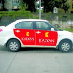 "Kalyan Jewellers cab branding on Swift Dzire – taxi wrap campaign by ACME Advertising in Delhi NCR."