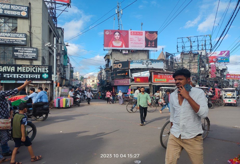 Aminabad Market street view in Lucknow with pedestrians, shops, and unipole advertising spaces by top Unipole advertising company in Lucknow.