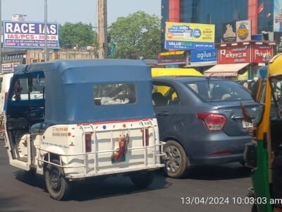 Busy Hussainganj Chauraha in Lucknow with traffic, shops, and prominent unipole billboards installed by Unipole advertising company in Lucknow.