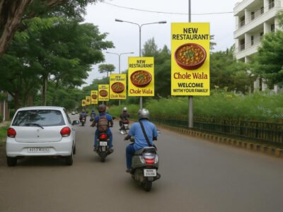 Yellow pole kiosk advertising companies in Lucknow banners by ACME Advertising Co. showing a bowl of chole and text “New Restaurant – Chole Wala – Welcome With Your Family” on urban street poles.