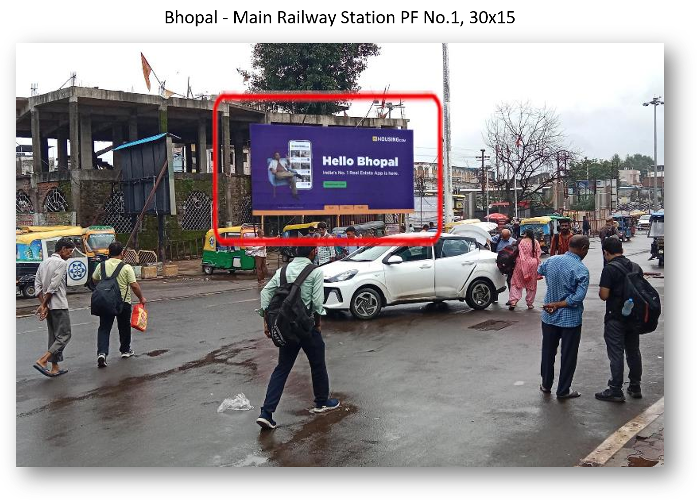 ACME Advertising Co.'s Housing.com billboard in Bhopal with autos, pedestrians, and urban street activity.