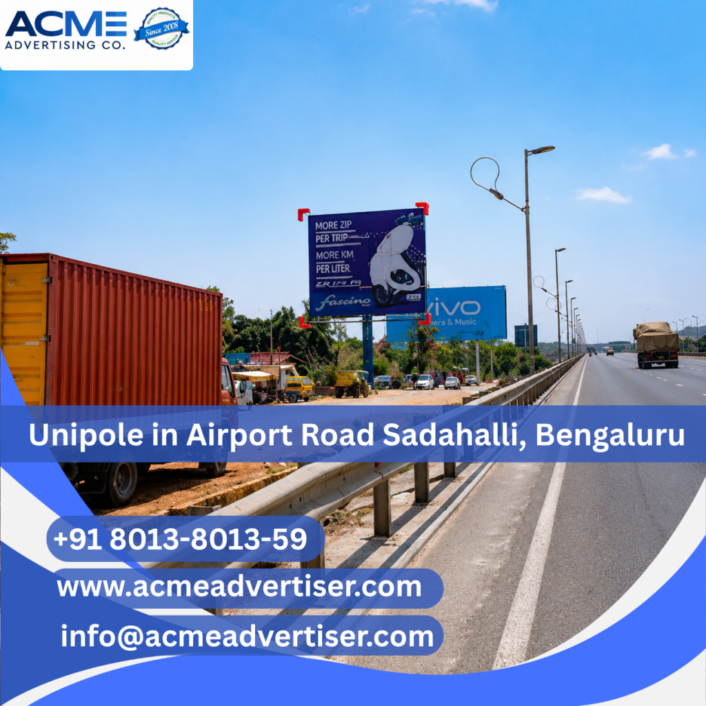 Large unipole advertising display by ACME Advertising Co. on Airport Road Sadahalli, Bengaluru at a prime high-traffic roadside location.
