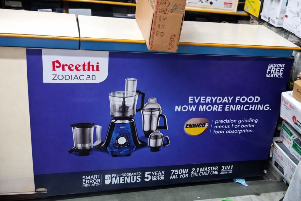Retail counter branding panel showcasing kitchen appliances and product features inside a store.